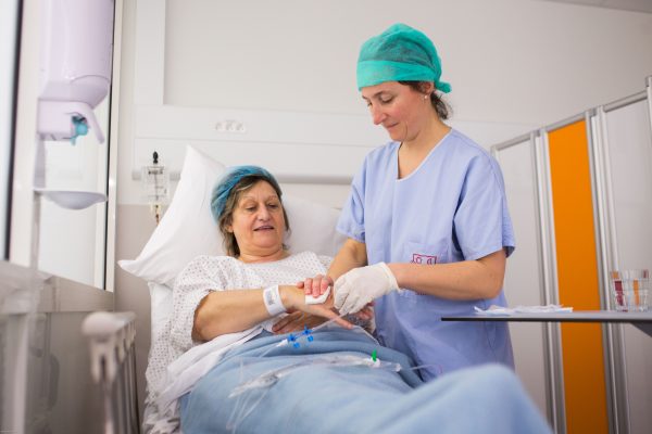 Une soignante accompagne une patiente en chirurgie ambulatoire